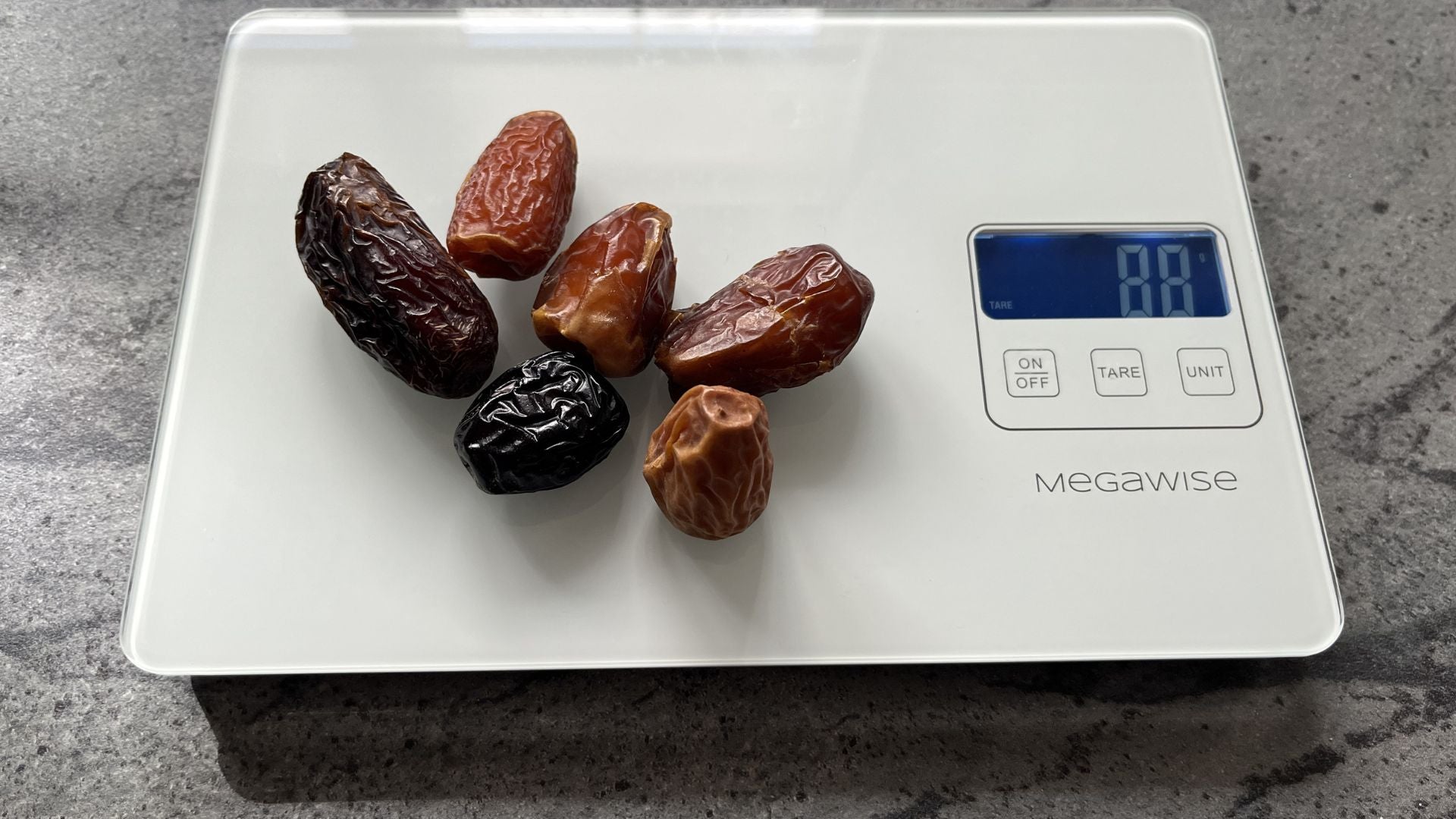 A mix of date varieties on a kitchen scale - portion control for weight loss